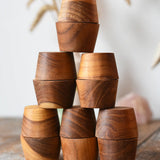 Papoose Toys 12 small natural wooden bowls placed on a wooden desk. 