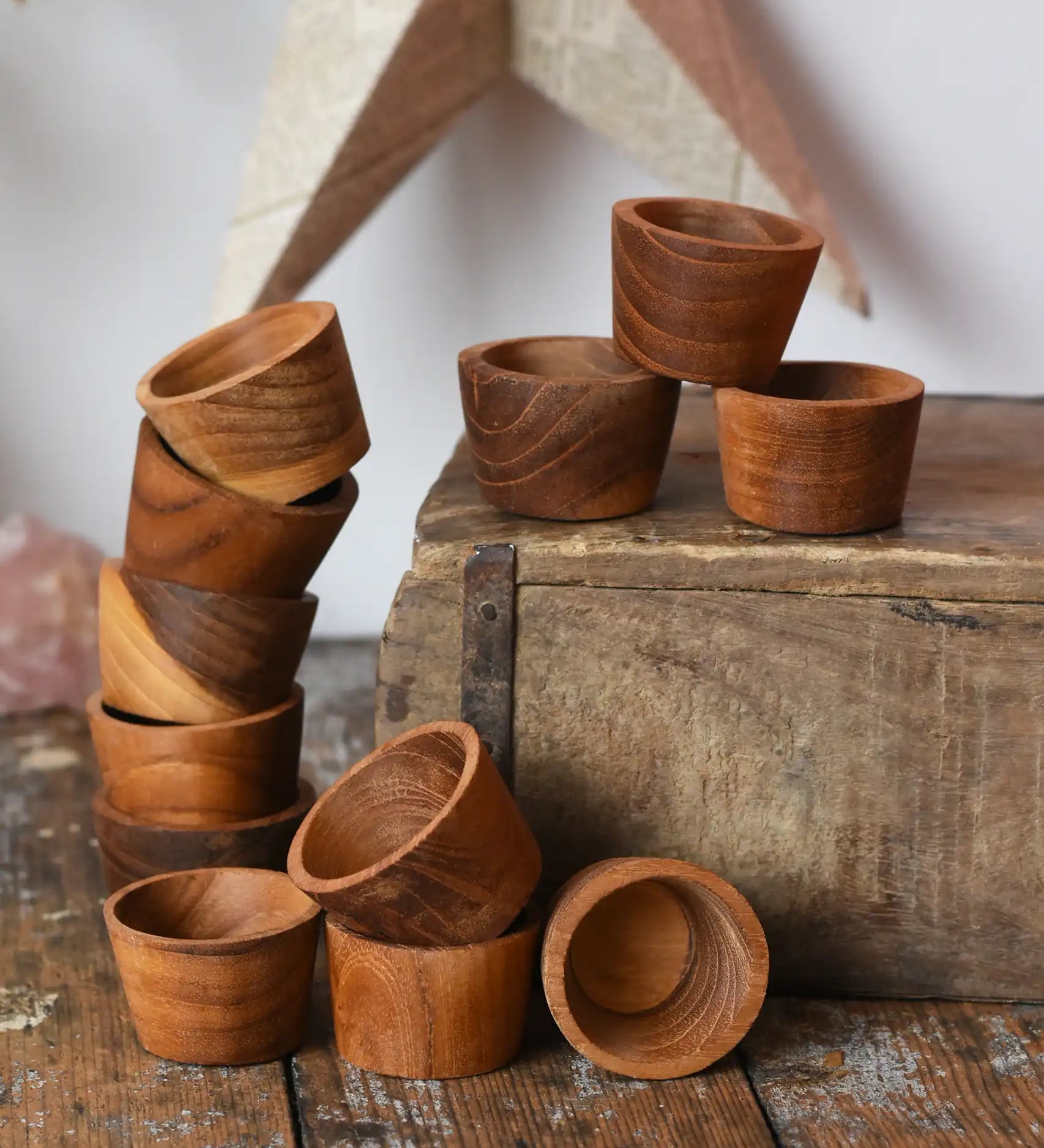 Papoose Toys 12 small natural wooden bowls placed on a wooden desk. 