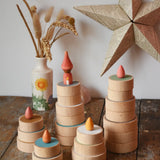 Papoose Toys wooden earth coins stacked up to create cakes with Grapat loose parts on top as candles.
