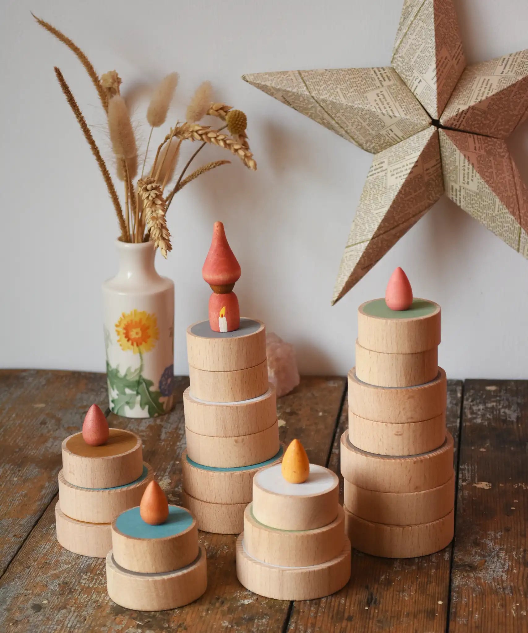 Papoose Toys wooden earth coins stacked up to create cakes with Grapat loose parts on top as candles.