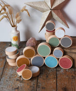 Papoose Toys wooden earth coins placed on a wooden desk.