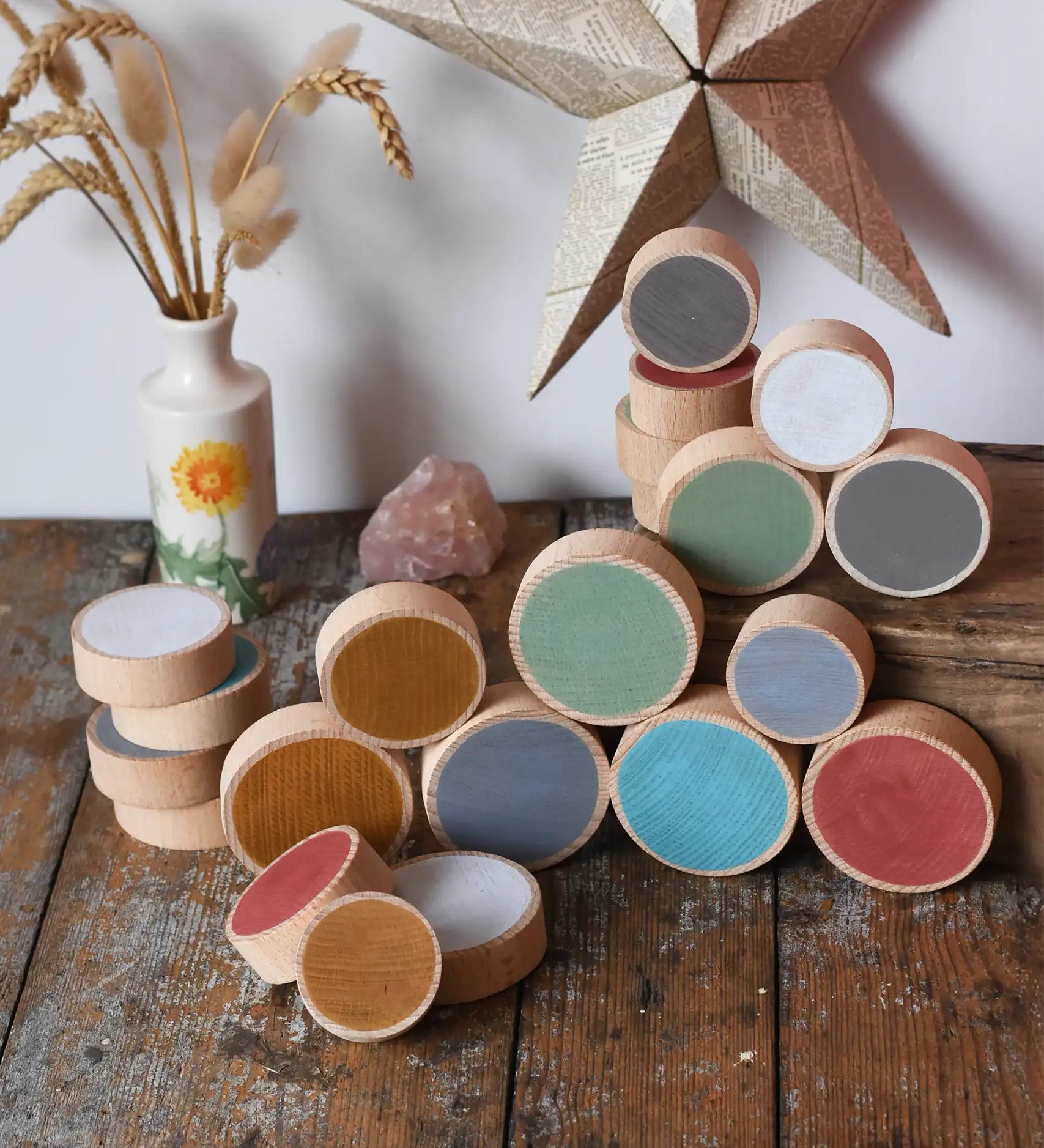 Papoose Toys wooden earth coins placed on a wooden desk.
