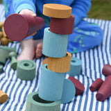 Rubes and discs from the Papoose Toys wooden earth tinker tray school set stacked up. Child knocking them down using the large red cone.