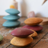 Red and yellow pebble from the  Papoose Toys earth wooden pebbles set stacked on top of each other. 