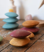Red and yellow pebble from the  Papoose Toys earth wooden pebbles set stacked on top of each other. 