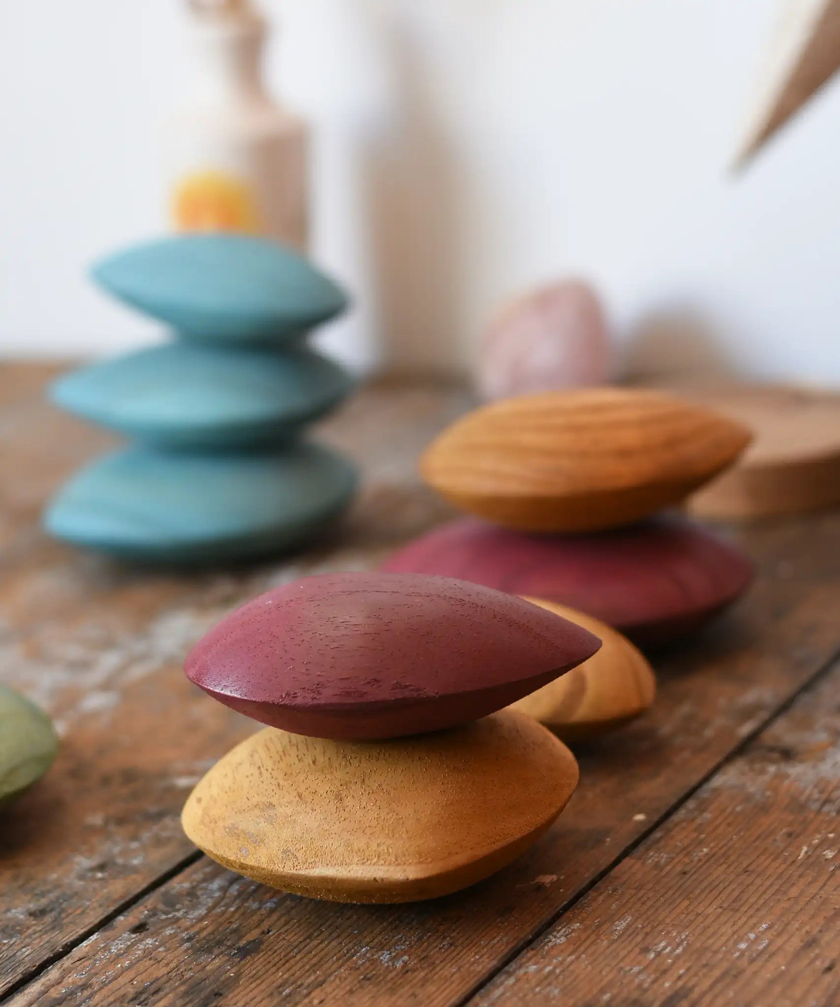 Red and yellow pebble from the  Papoose Toys earth wooden pebbles set stacked on top of each other. 