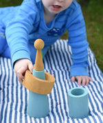 Child playing with pieces from the Papoose Toys wooden earth tinker tray school set.