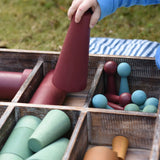Close up of the Papoose Toys wooden earth tinker tray school set with the large red cone in a child's hand.