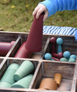 Close up of the Papoose Toys wooden earth tinker tray school set with the large red cone in a child's hand.