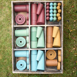 Papoose Toys wooden earth tinker tray school set placed on grass.