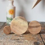 Papoose Toys wooden natural stacking discs on a wooden desk. 
