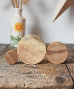 Papoose Toys wooden natural stacking discs on a wooden desk. 
