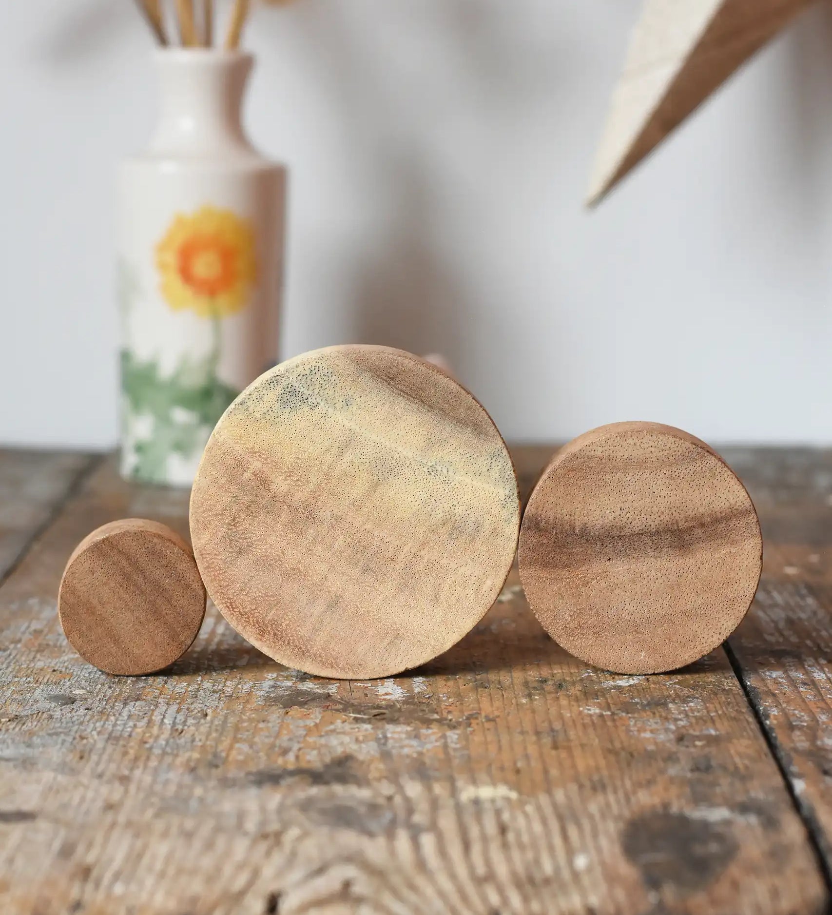 Papoose Toys wooden natural stacking discs on a wooden desk. 