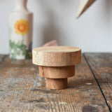 Papoose Toys wooden natural stacking discs on a wooden desk. 