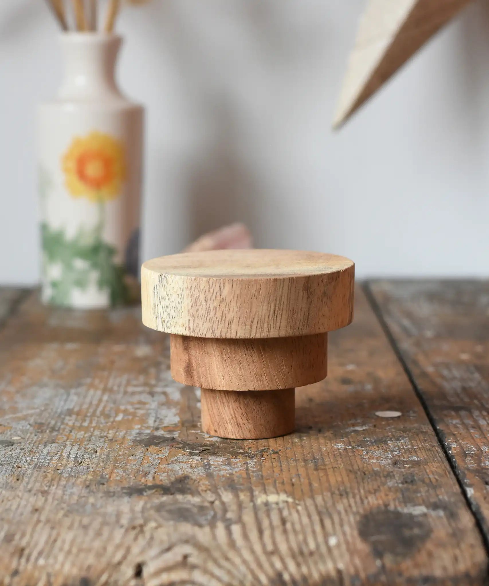 Papoose Toys wooden natural stacking discs on a wooden desk. 