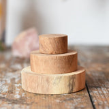 Papoose Toys wooden natural stacking discs on a wooden desk. 