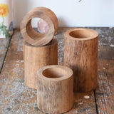 Papoose Toys wooden stacking tubes placed on a wooden surface.