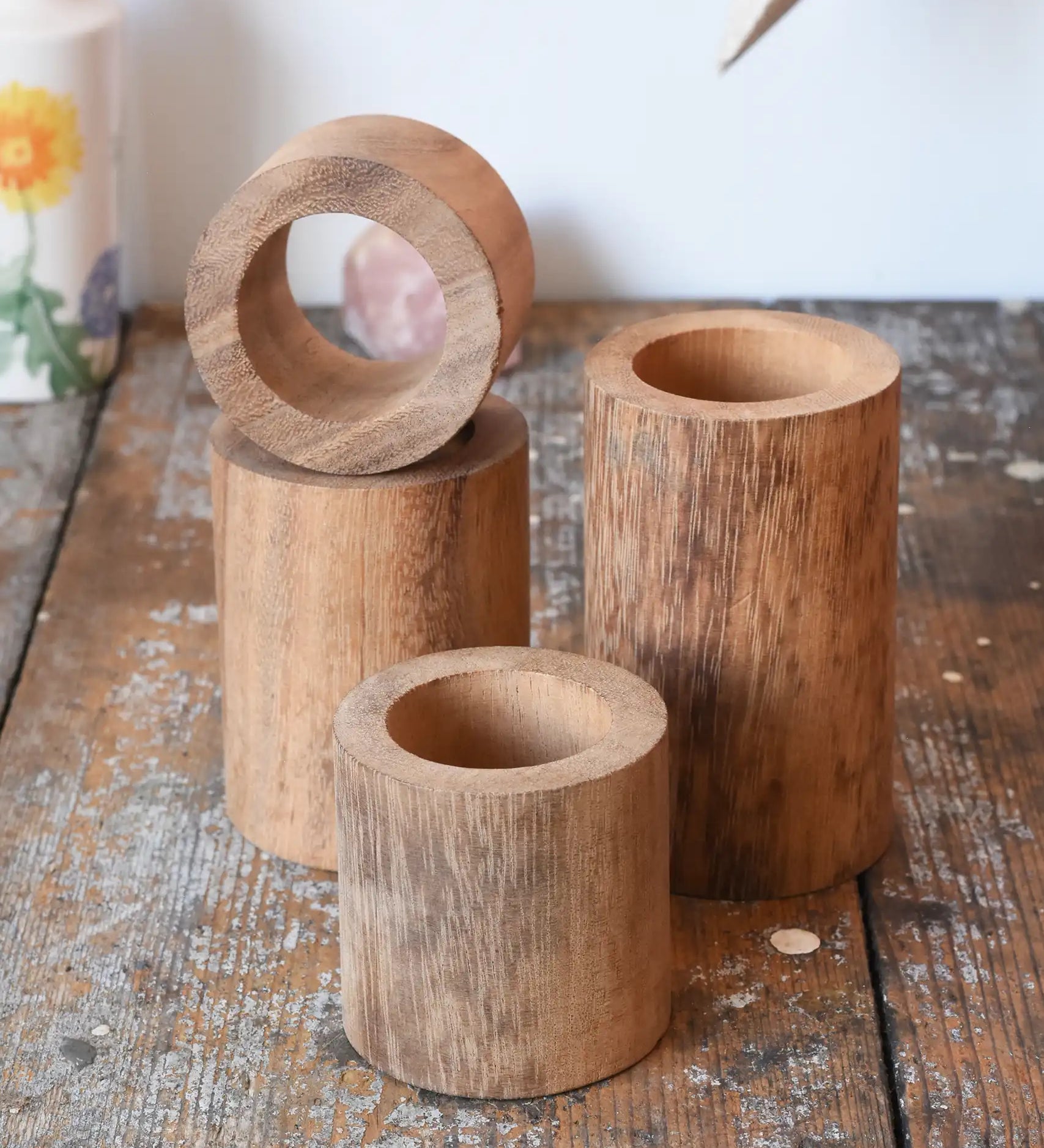 Papoose Toys wooden stacking tubes placed on a wooden surface.