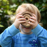 Child looking through the Papoose nesting tubes holding them up over his eyes.