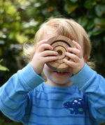 Child looking through the Papoose nesting tubes holding them up over his eyes.