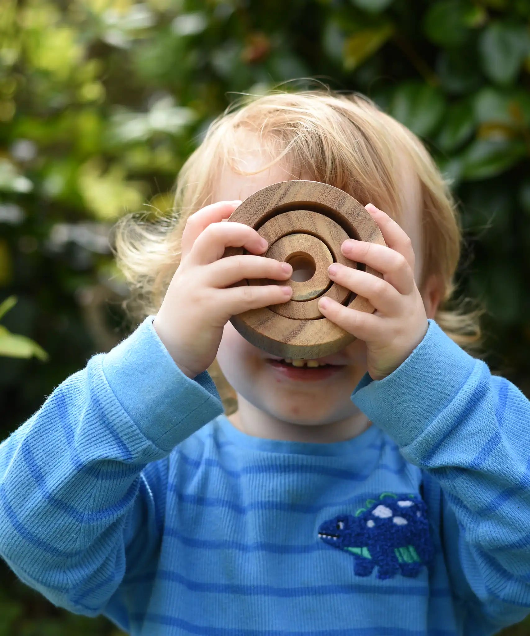 Child looking through the Papoose nesting tubes holding them up over his eyes.