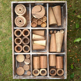 Papoose Toys wooden tinker tray school set placed on grass.