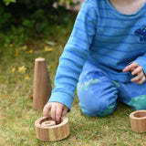 Child playing with Papoose nesting tubes on grass. 