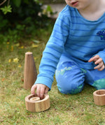 Child playing with Papoose nesting tubes on grass. 