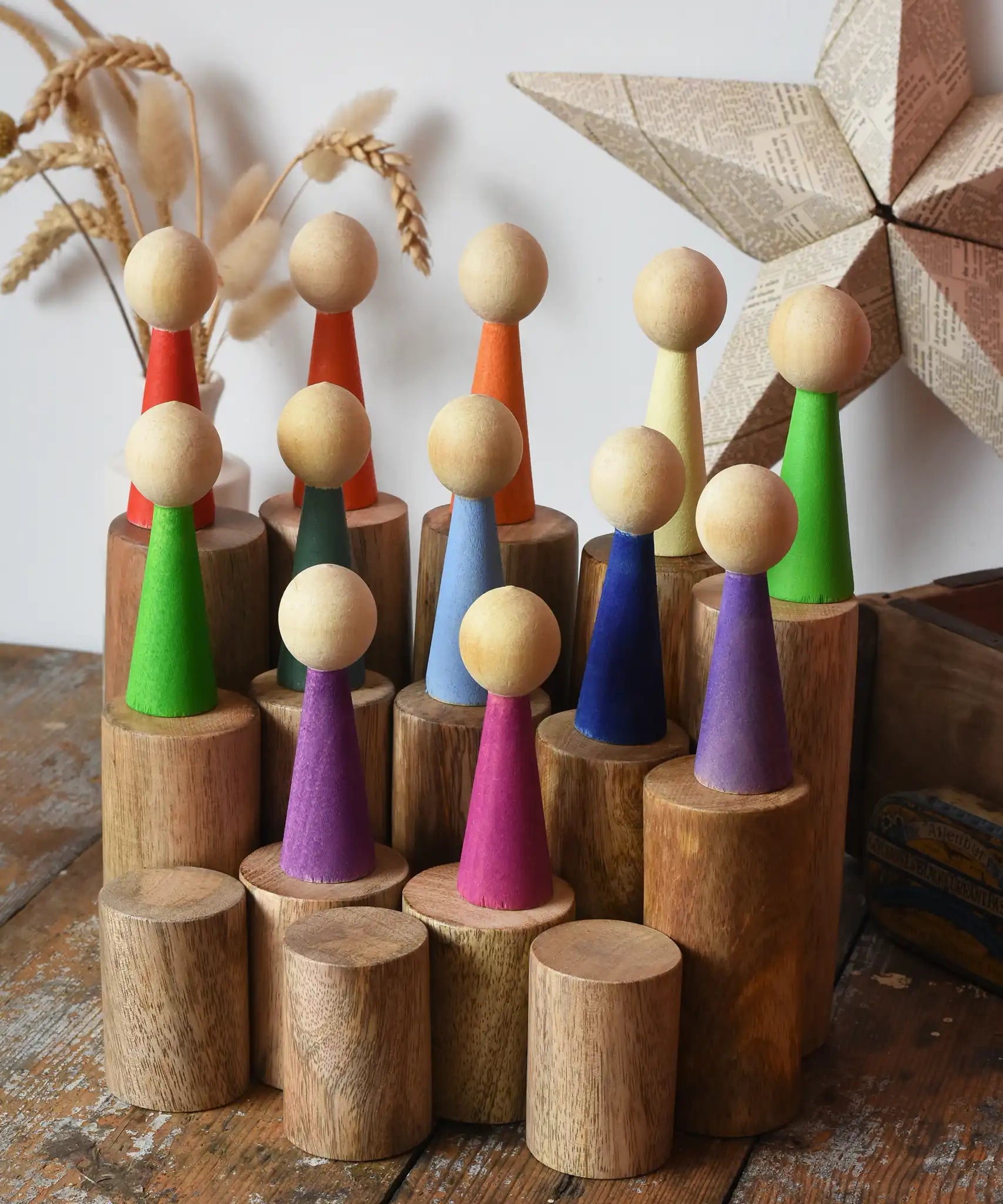 Papoose Toys wooden stacking trunks placed on a wooden desk with Goethe rainbow people placed on top.