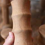 Large ridged spool from the Papoose Toys handmade wooden spool shape set in an adult's hand.