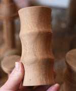 Large ridged spool from the Papoose Toys handmade wooden spool shape set in an adult's hand.