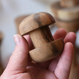 Round headed spool from the Papoose Toys handmade wooden spool shape set in an adult's hand.