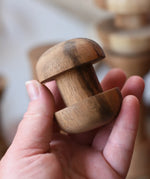 Round headed spool from the Papoose Toys handmade wooden spool shape set in an adult's hand.
