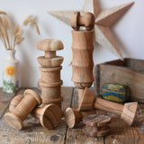 Papoose Toys handmade wooden spool shape set placed on a wooden desk. 