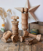 Papoose Toys handmade wooden spool shape set placed on a wooden desk. 