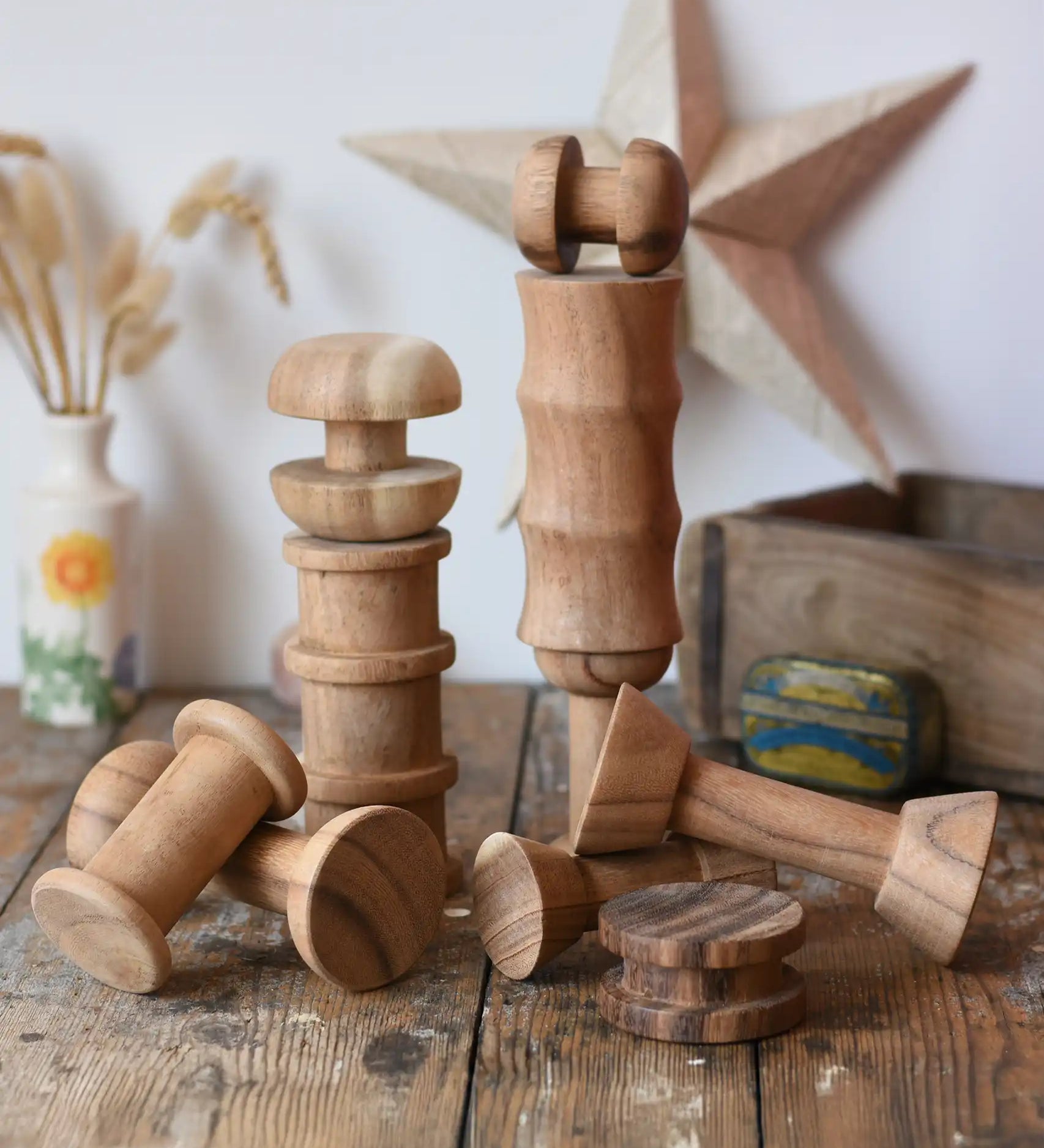 Papoose Toys handmade wooden spool shape set placed on a wooden desk. 