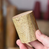 Short Papoose Toys wooden stacking trunks in an adult's hand.