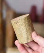 Short Papoose Toys wooden stacking trunks in an adult's hand.