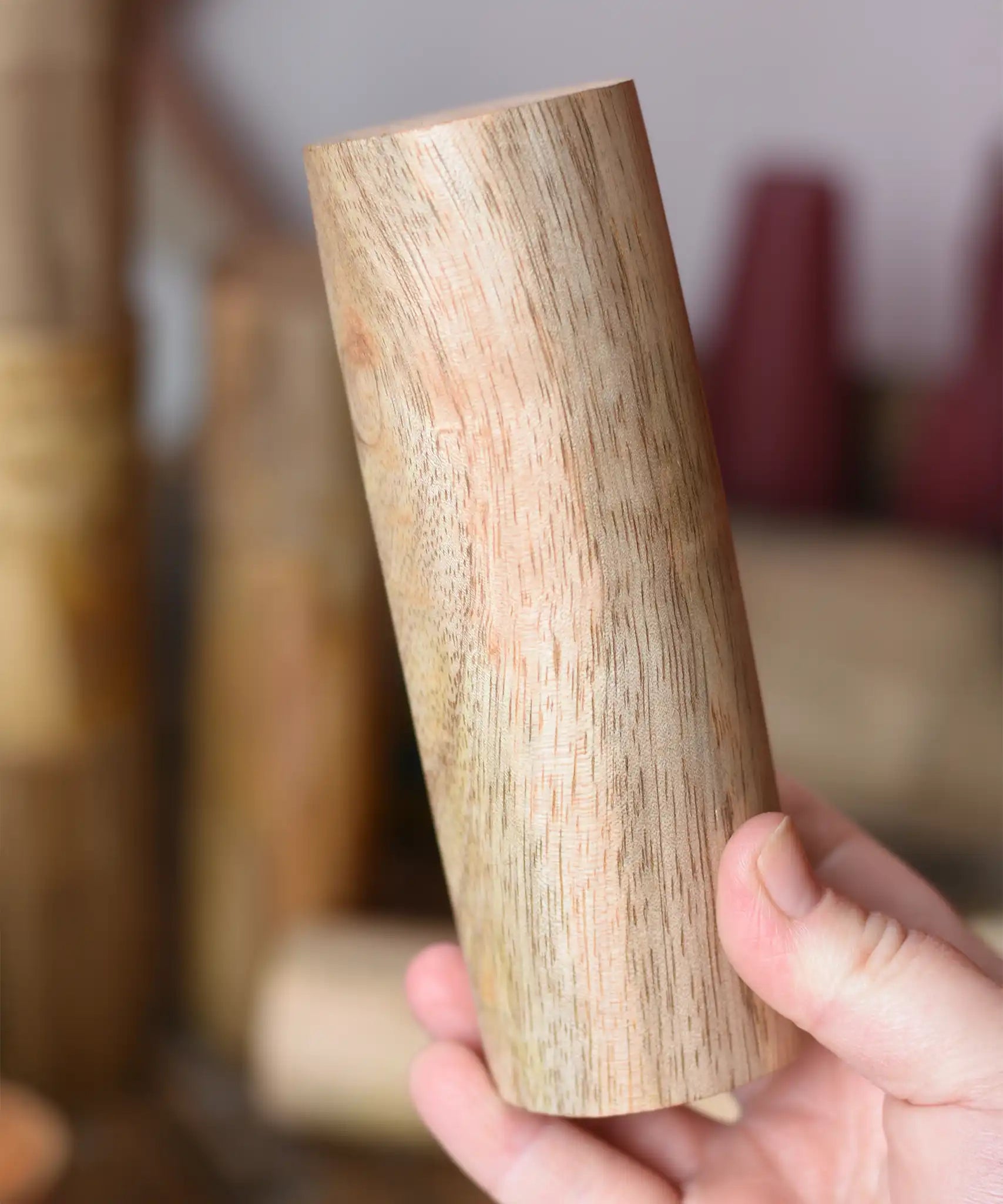 Tall Papoose Toys wooden stacking trunk in an adult's hand.