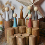 Papoose Toys wooden stacking trunks placed on a wooden desk with earth people peg dolls placed on top.