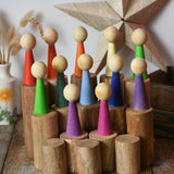Papoose Toys wooden stacking trunks placed on a wooden desk with Goethe rainbow people placed on top.