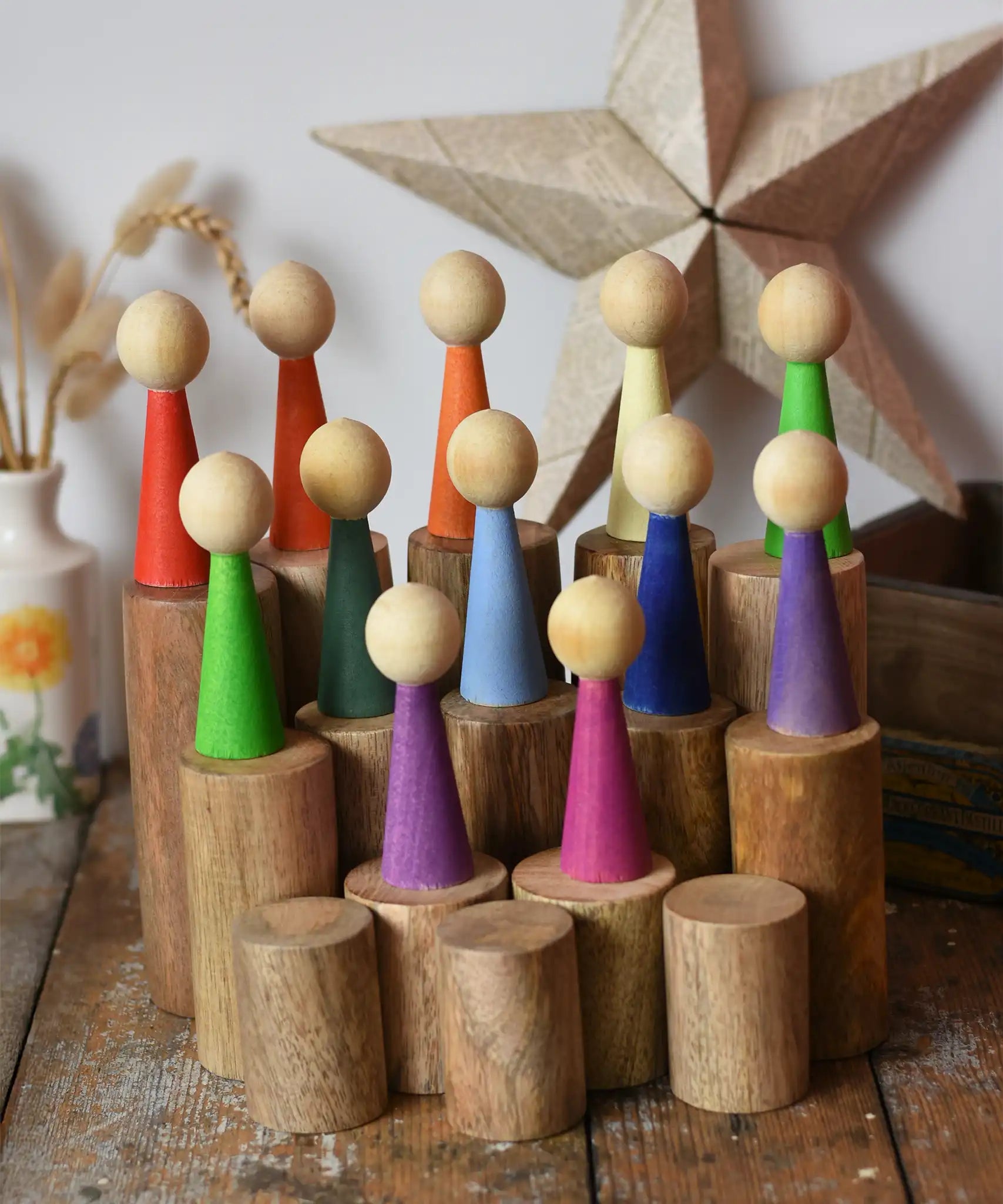 Papoose Toys wooden stacking trunks placed on a wooden desk with Goethe rainbow people placed on top.