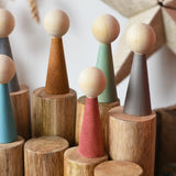 Papoose Toys wooden stacking trunks with earth people wooden peg dolls placed on top.