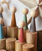Papoose Toys wooden stacking trunks with earth people wooden peg dolls placed on top.