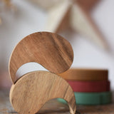 Papoose Toys wooden yim yams in natural wood placed on a wooden board.