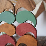 Papoose Toys wooden earth and natural yim yams stacked on a wooden desk.