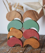Papoose Toys wooden earth and natural yim yams  stacked up on a wooden desk.