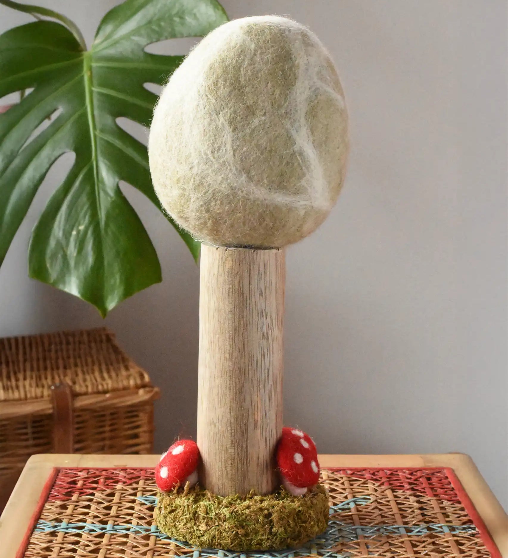 Papoose Toys Winter felt woodland tree placed on a rattan top stool. 