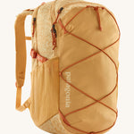Patagonia 30L yellow refugio day backpack with a flower design on a cream background.