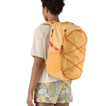 Patagonia 30L yellow refugio day backpack with a flower design  worn by an adult